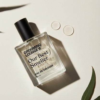 Perfume bottle labeled 'Grooming Lounge Our Best Smeller' on a light background